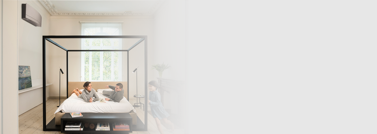 Happy family in a bedroom with a wall mounted Daikin Emura unit.